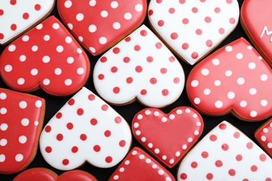 Photo of Delicious heart shaped cookies on dark background, flat lay. Valentine's Day