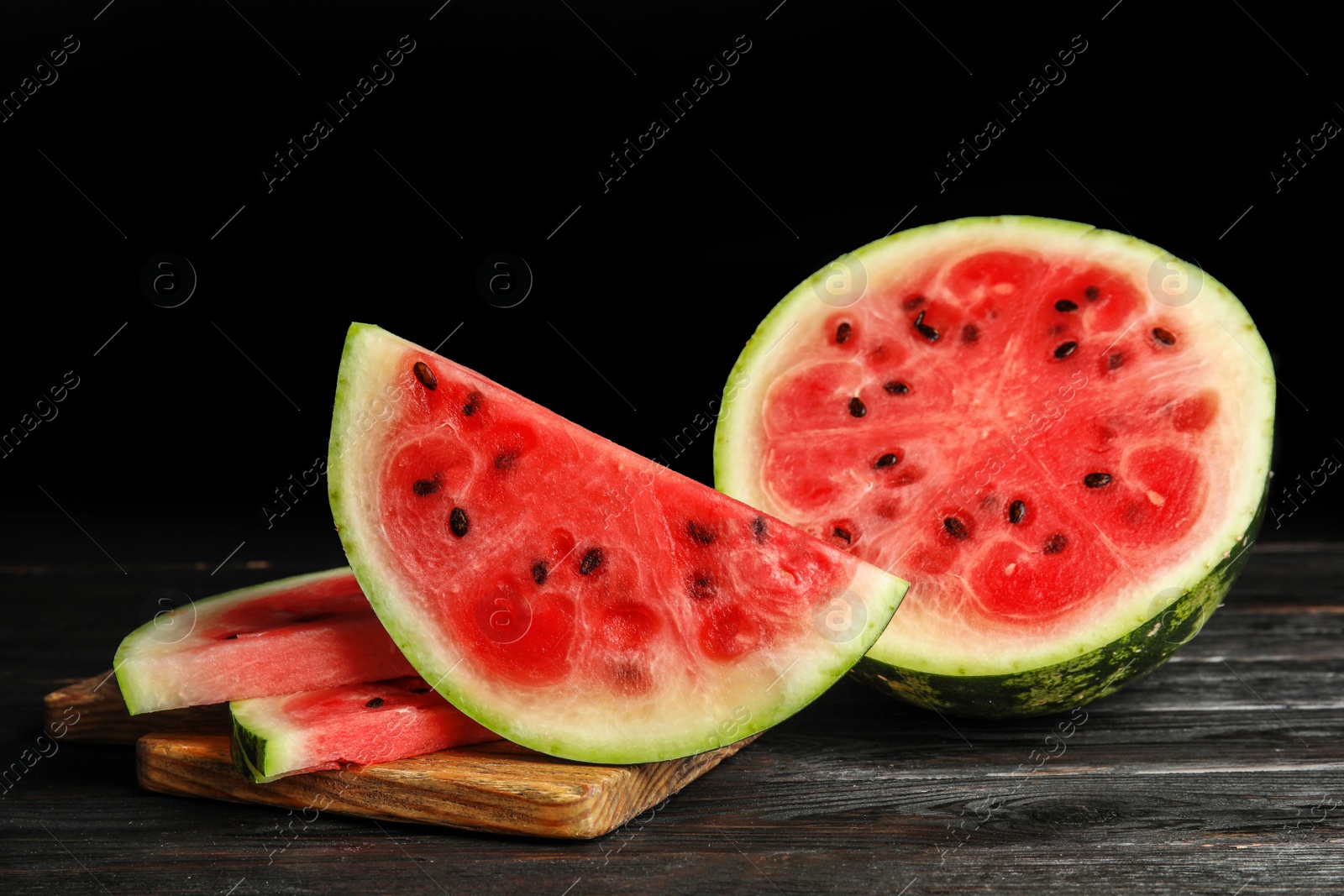 Photo of Wooden board with juicy watermelon slices on table