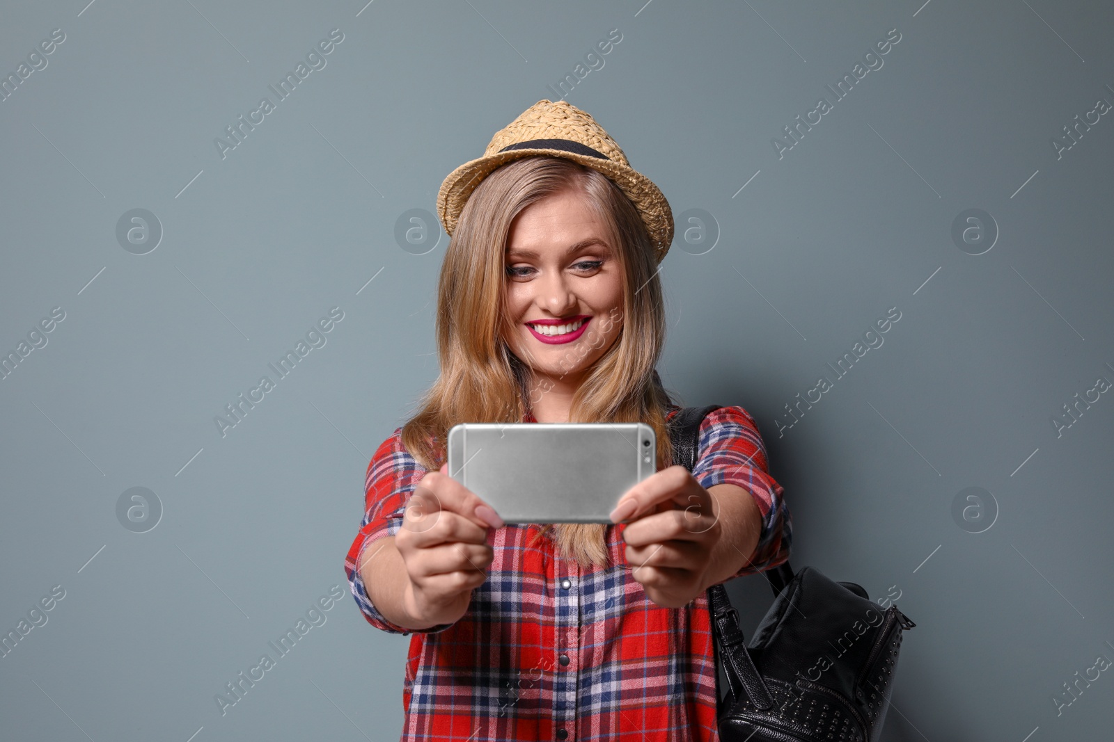 Photo of Attractive young woman taking selfie on color background