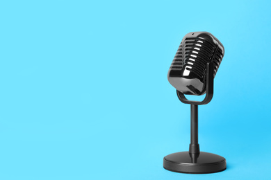 Photo of Retro microphone on light blue background, space for text. Interview