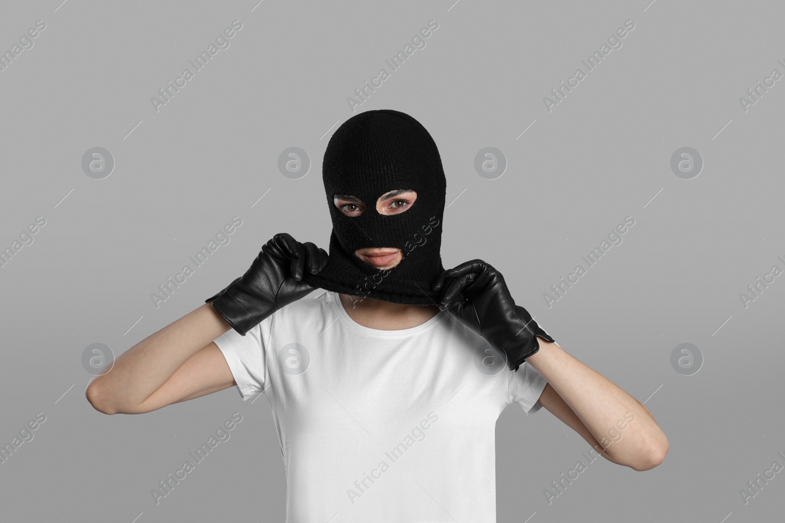 Photo of Woman wearing knitted balaclava on grey background