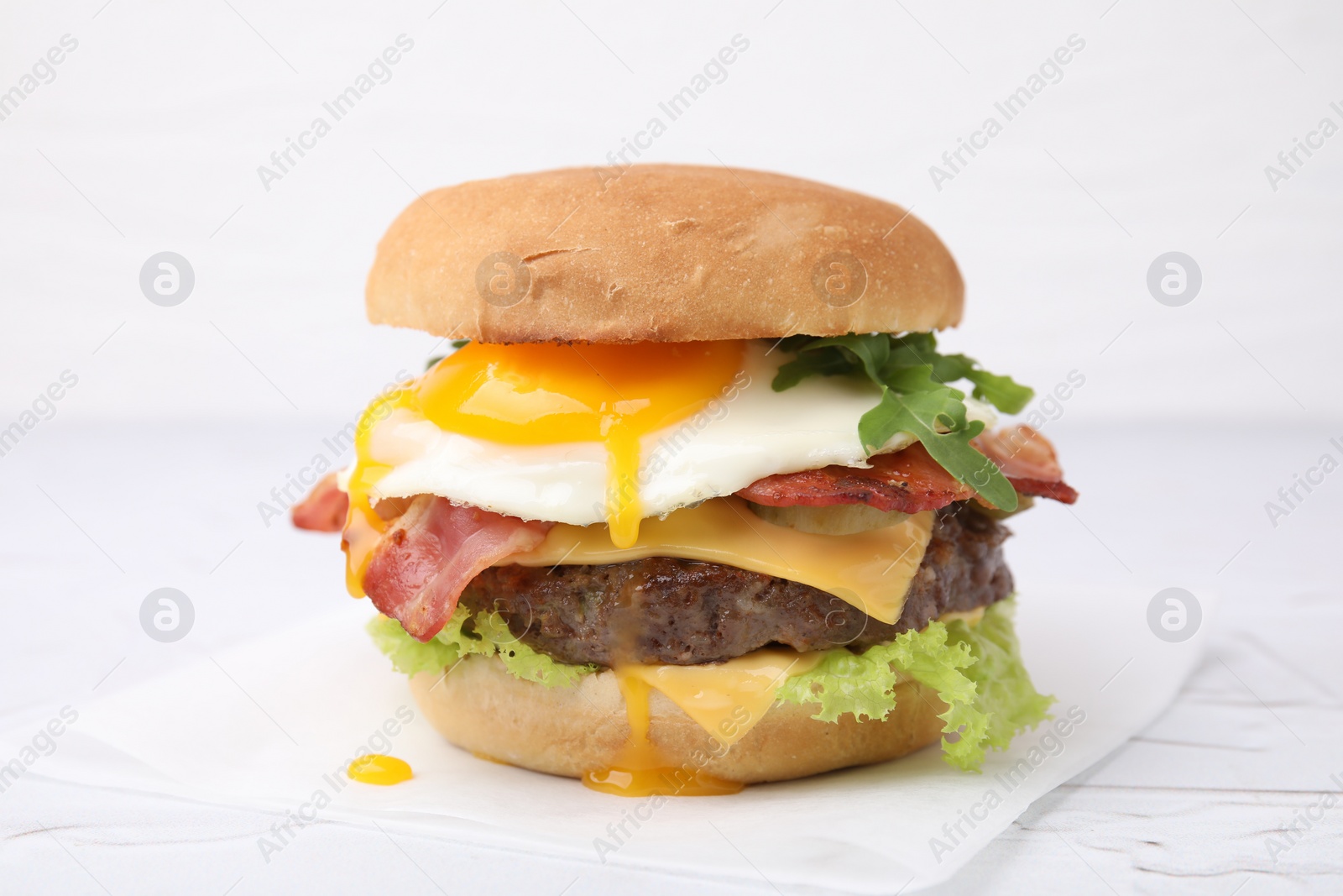 Photo of Delicious burger with fried egg on white table