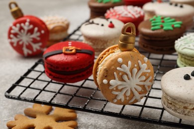 Beautifully decorated Christmas macarons on light grey table, closeup