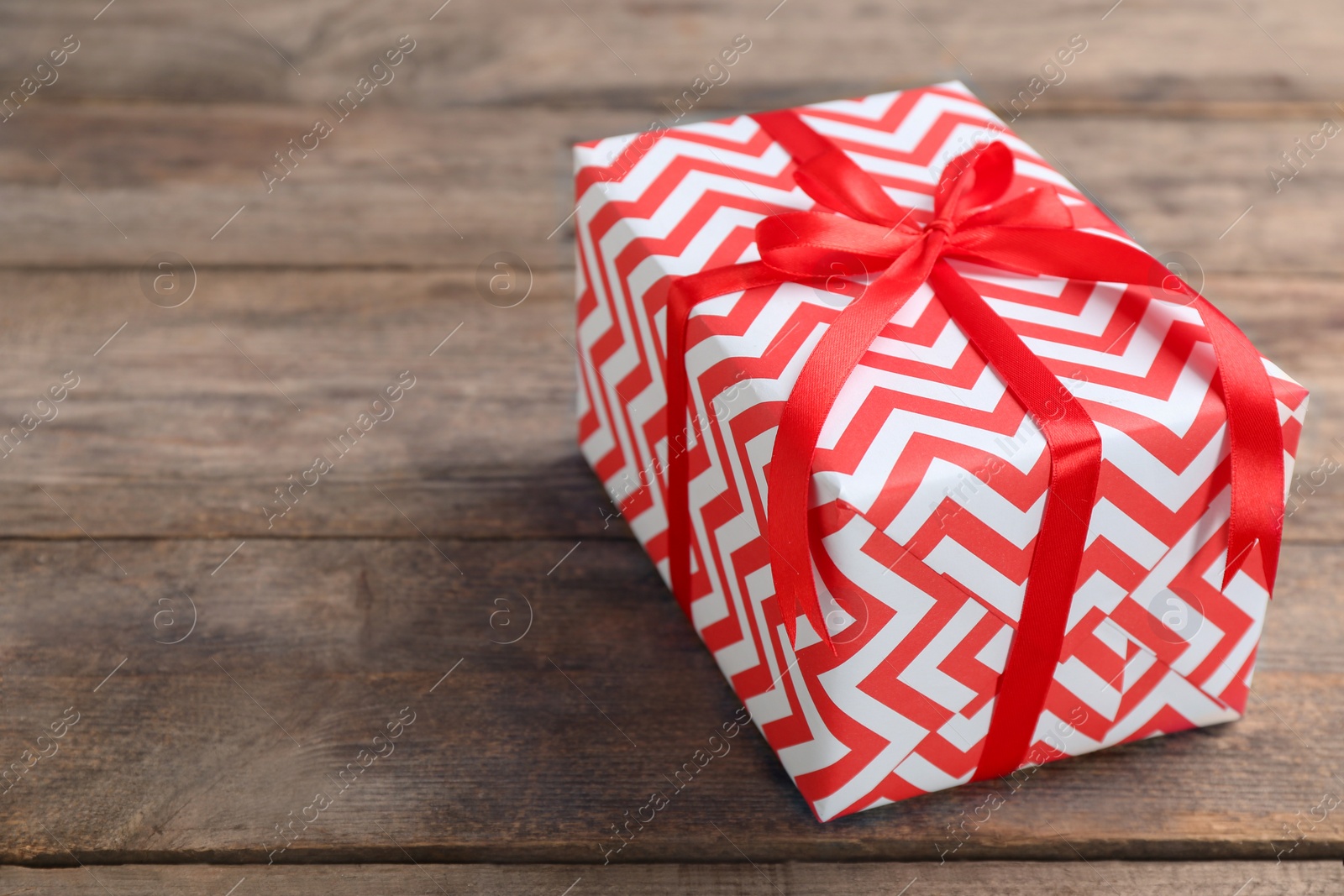 Photo of Elegant gift box with bow on wooden background