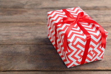 Elegant gift box with bow on wooden background