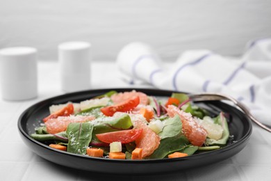 Photo of Delicious salad with pomelo, tomatoes and cheese on white tiled table