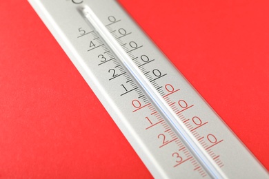 Modern weather thermometer on red background, closeup