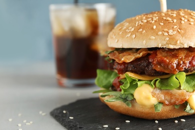 Tasty burger with bacon served on table, closeup. Space for text