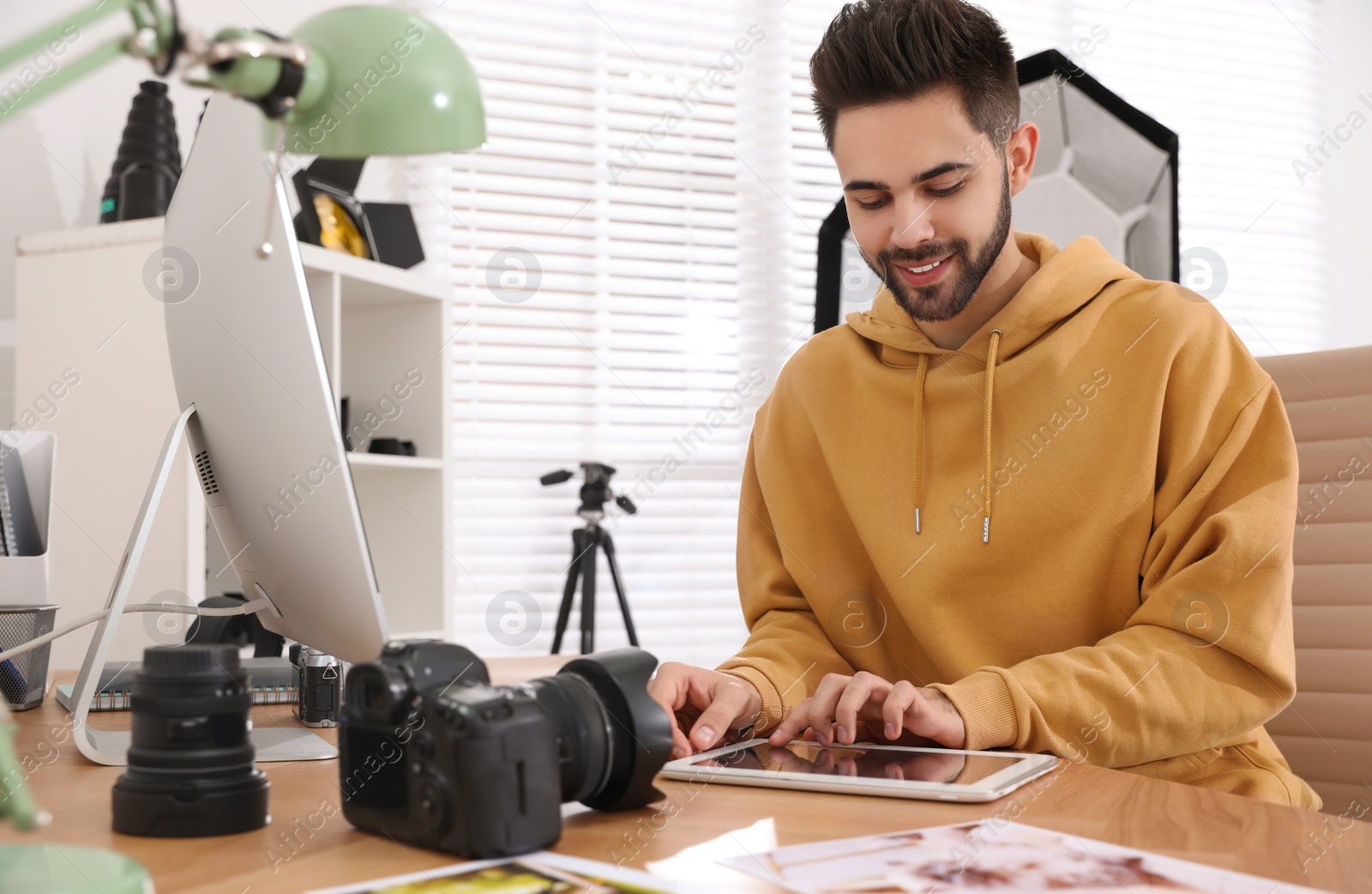 Photo of Professional photographer working at table in office