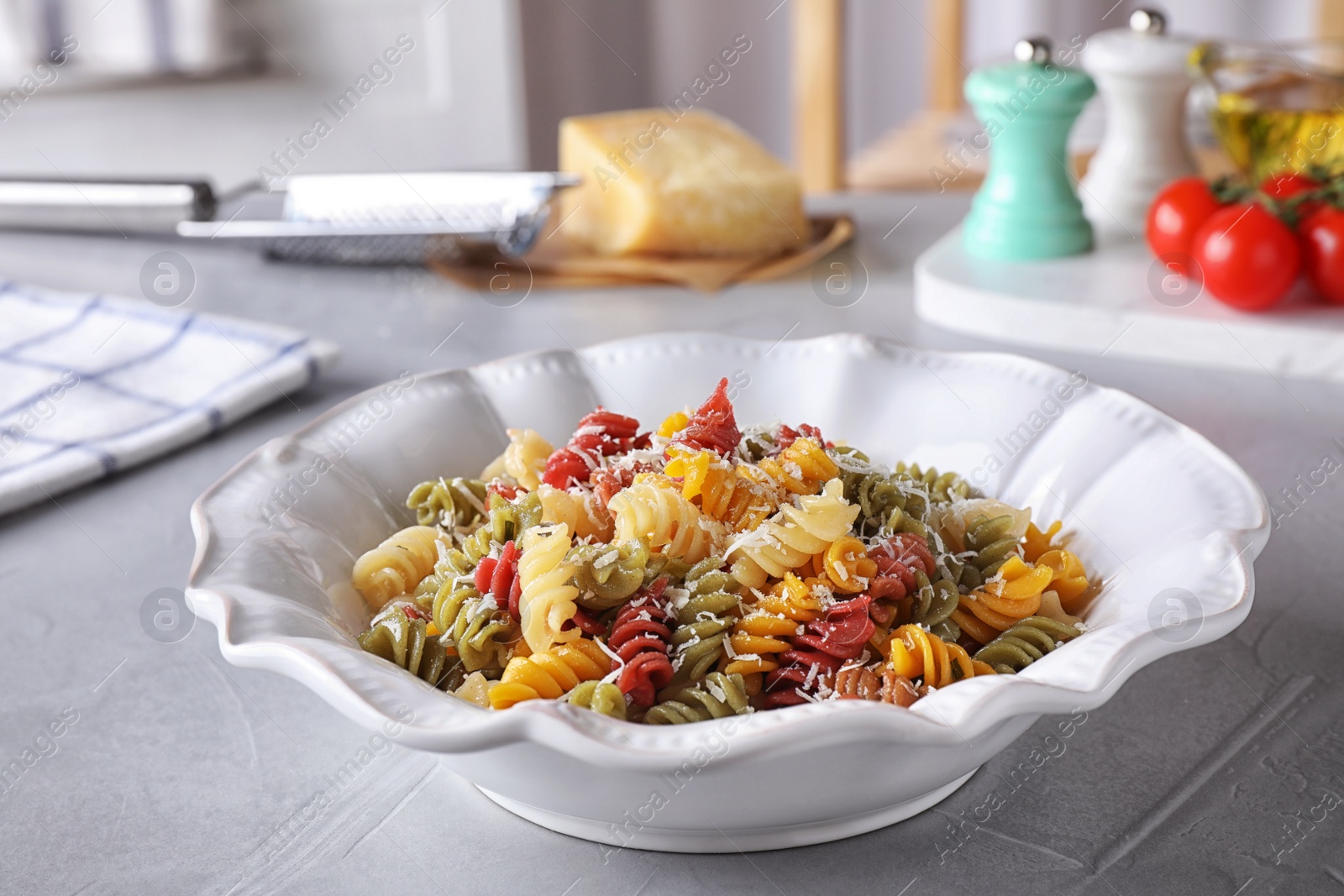 Photo of Delicious colorful pasta on light grey table