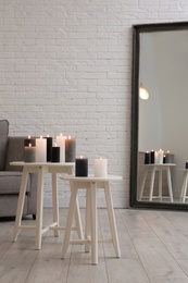 Photo of Burning candles on tables in living room