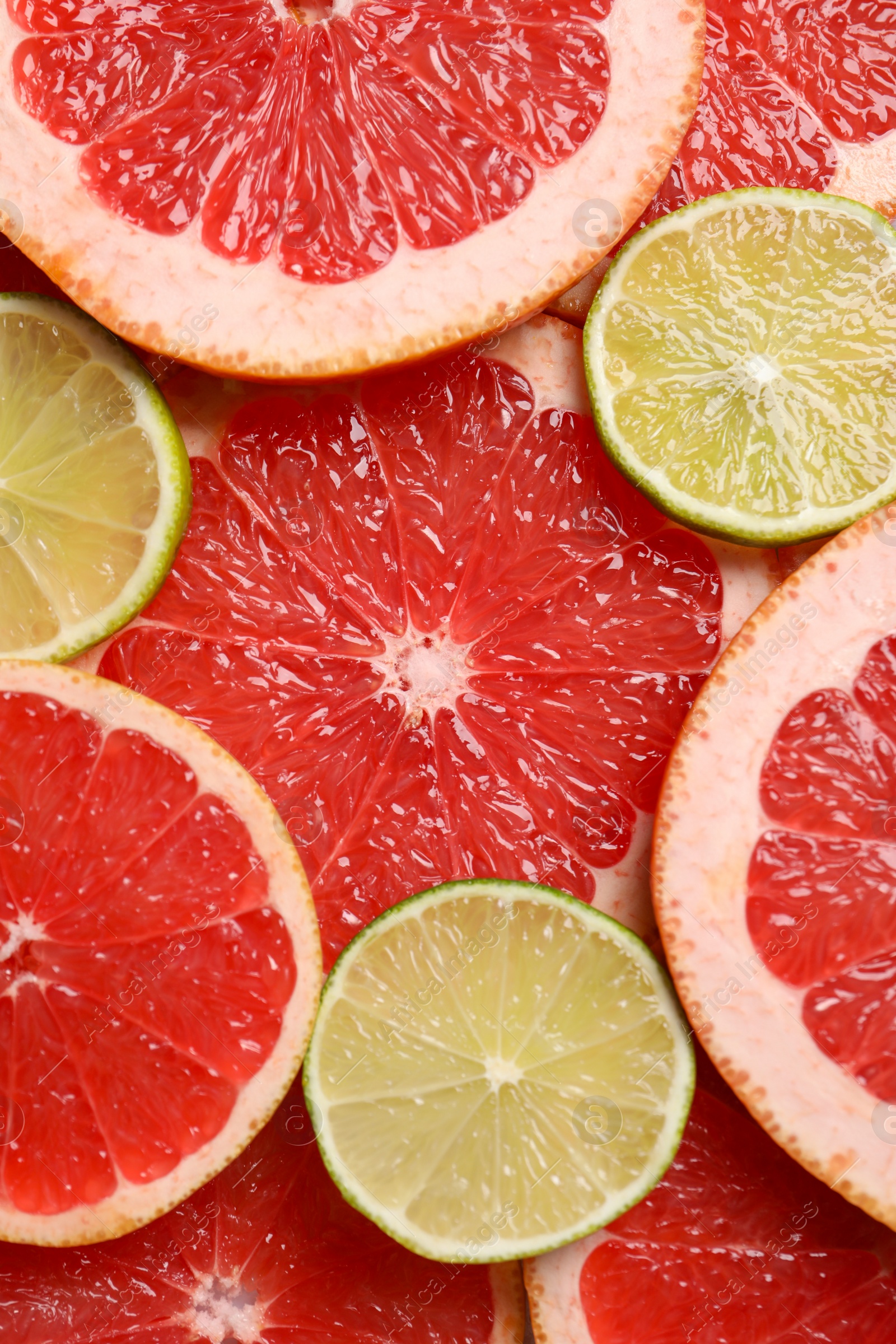 Photo of Slices of grapefruit and lime as background, top view