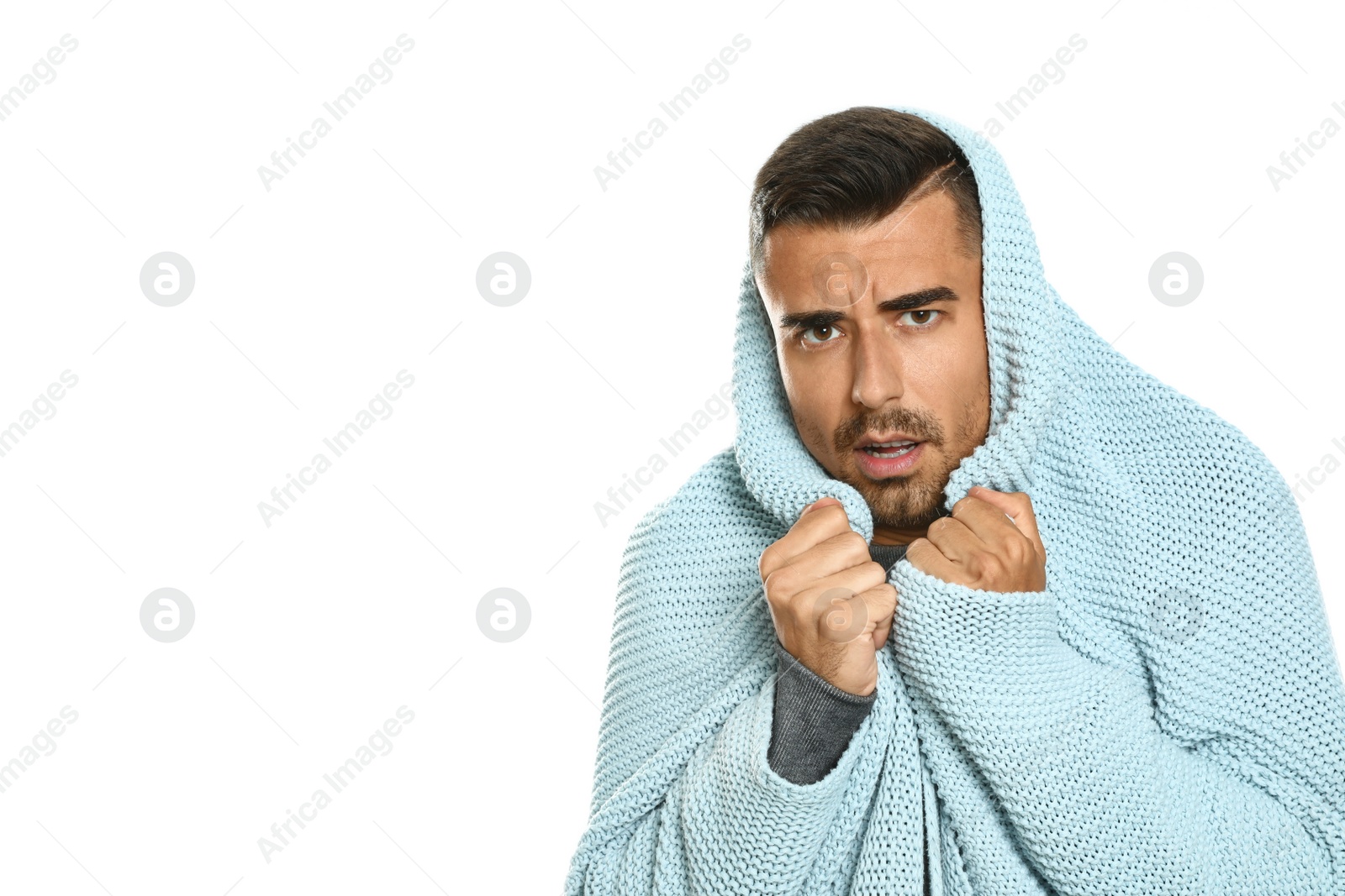 Photo of Young man wrapped in blanket suffering from cold on white background