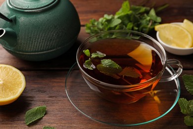 Photo of Aromatic herbal tea with mint and lemon on wooden table