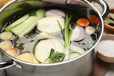 Pot with different ingredients for cooking tasty bouillon, closeup