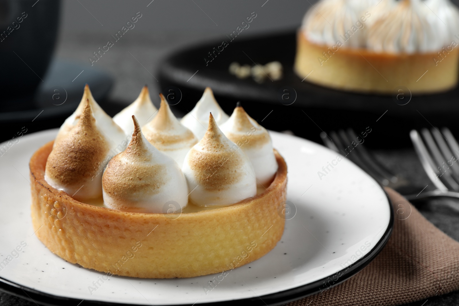 Photo of Tartlet with meringue served on table, closeup. Tasty dessert