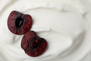 Tasty yogurt with cut cherry as background, top view. Space for text