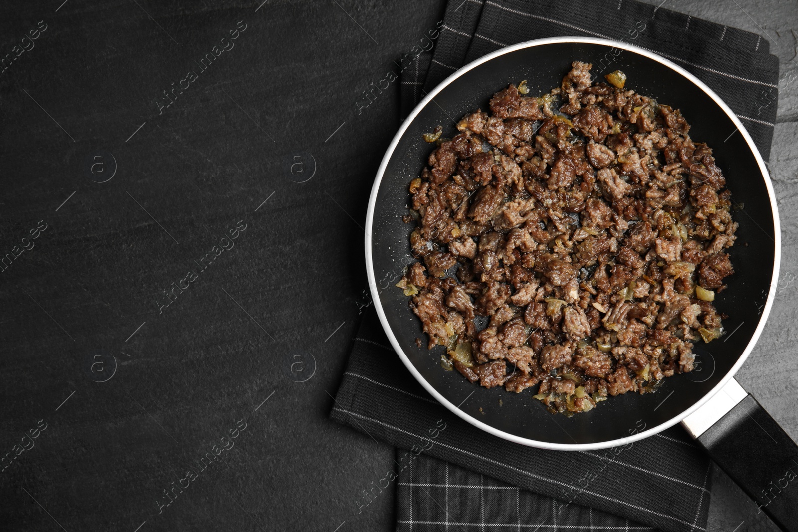 Photo of Fried minced meat with onion on black table, top view. Space for text