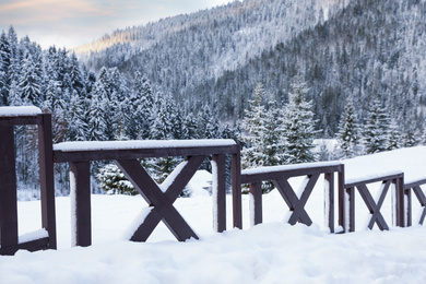 Photo of Wooden fence covered with snow outdoors on winter day