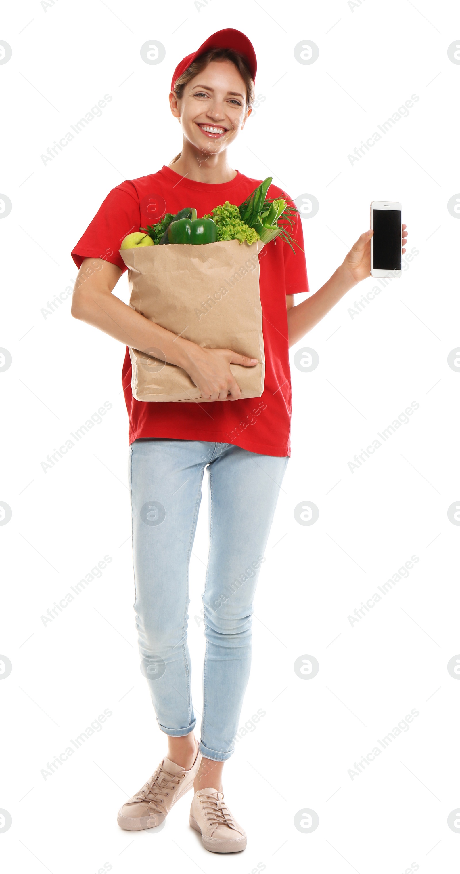 Photo of Delivery woman with bag of fresh vegetables and smartphone on white background, mockup for design