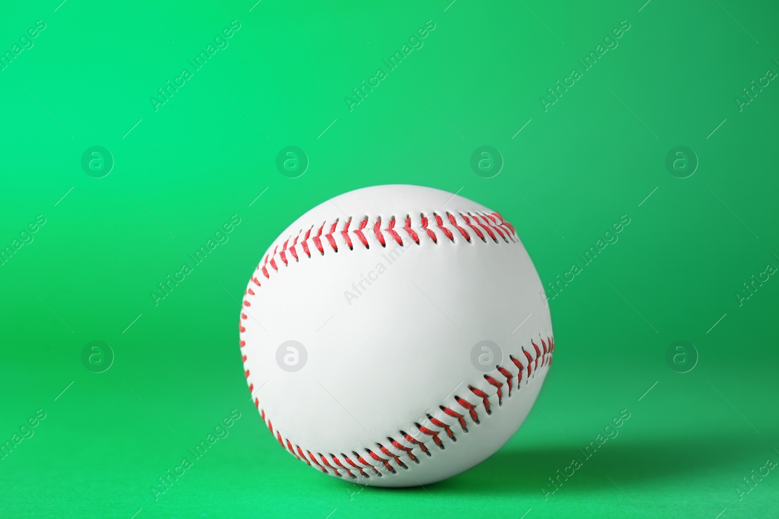 Photo of Baseball ball on green background, closeup. Sports game