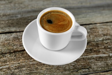 Photo of Cup of tasty coffee on wooden table