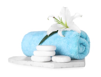 Photo of Composition with towel, spa stones and fresh flower isolated on white