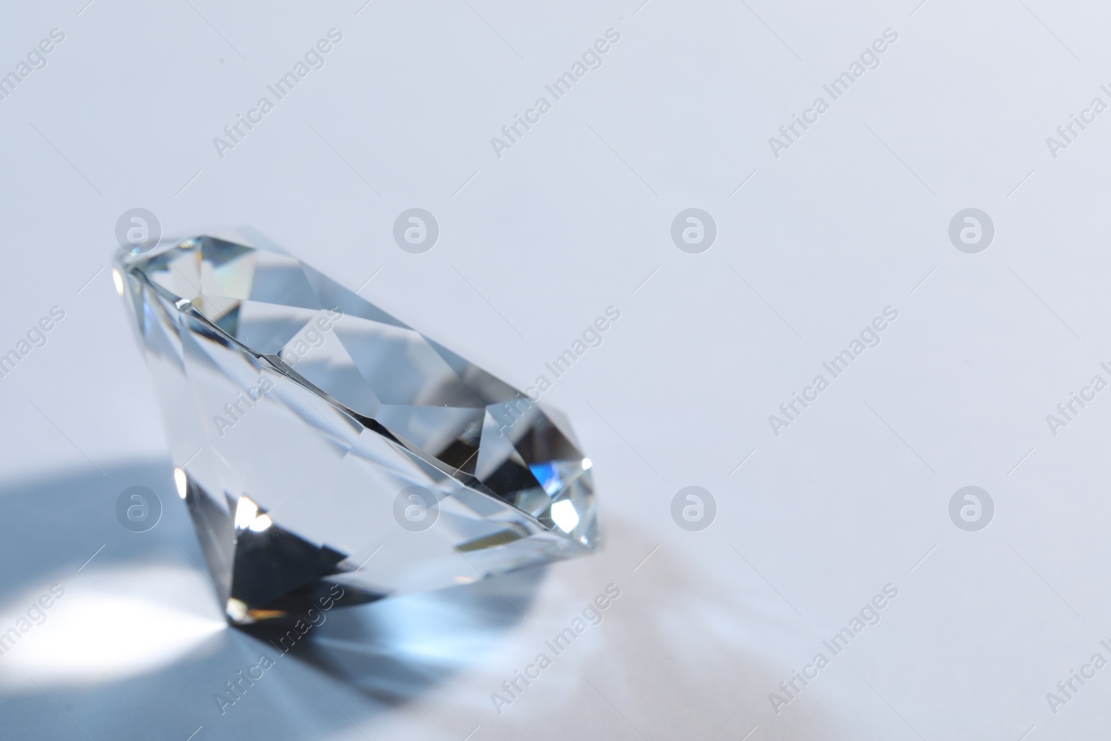 Photo of Beautiful dazzling diamond on white background, closeup. Space for text