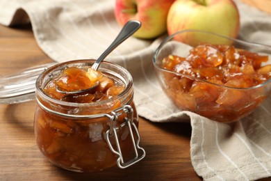 Photo of Tasty apple jam and fresh fruits on wooden table
