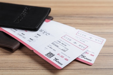 Photo of Avia tickets and passports on wooden table, closeup. Travel agency concept