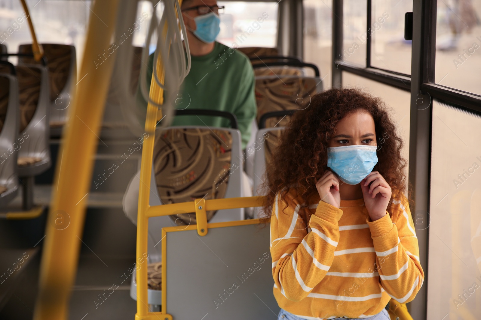 Photo of African-American woman with disposable mask on bus. Virus protection