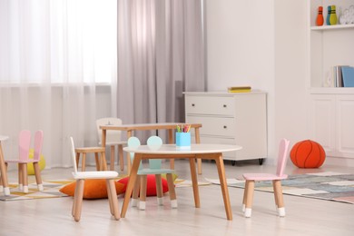 Photo of Child`s playroom with comfortable furniture. Stylish kindergarten interior
