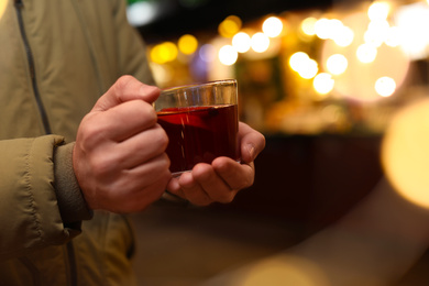 Photo of Man with mulled wine at winter fair, closeup