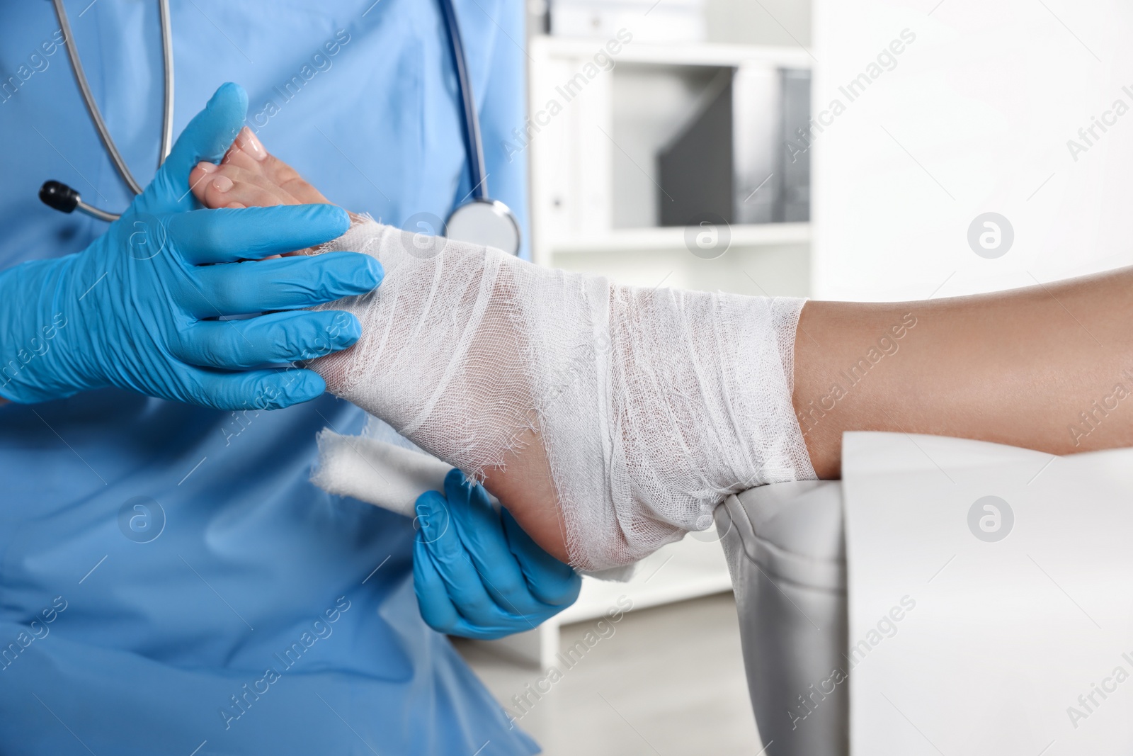 Photo of Doctor applying bandage onto patient's foot in hospital, closeup