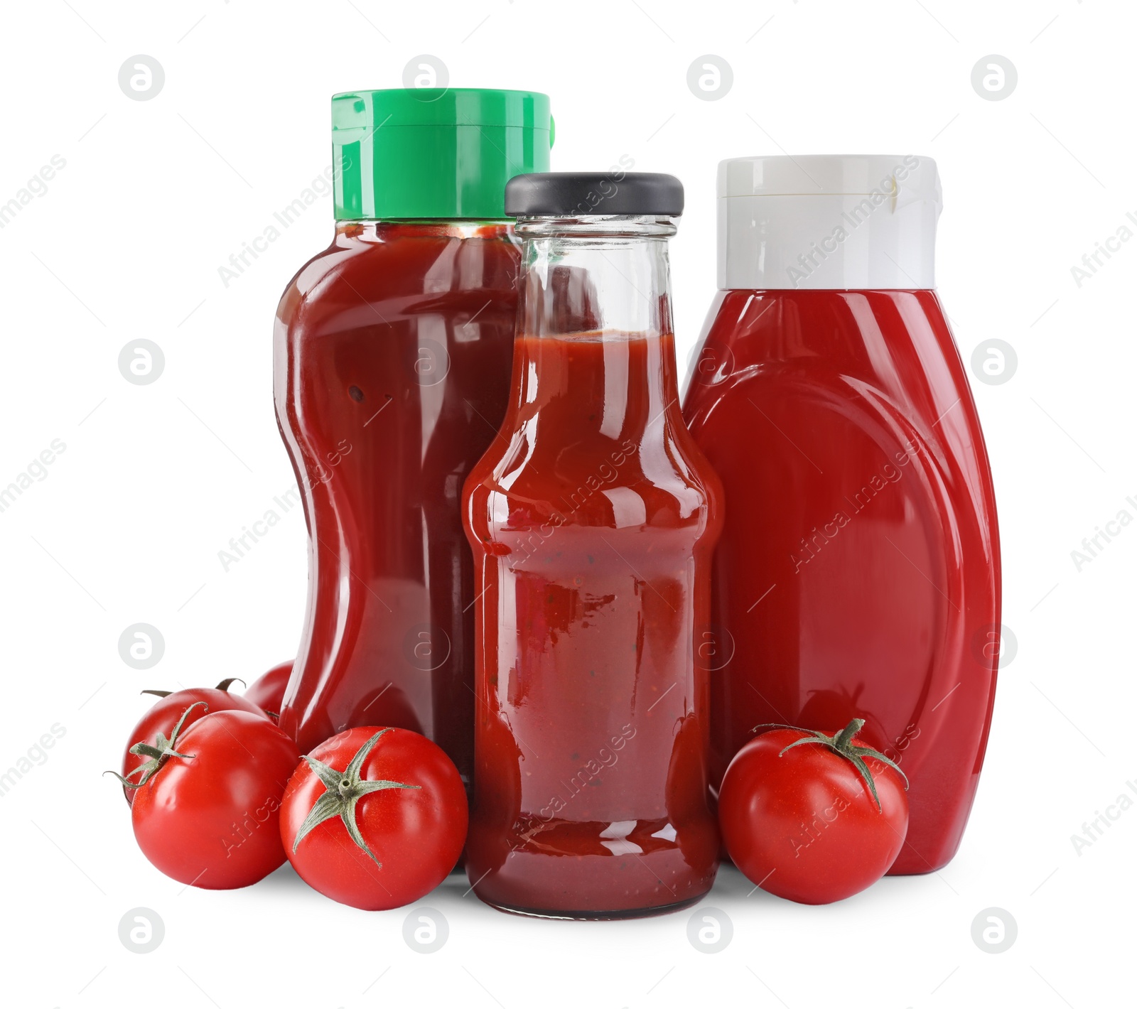 Photo of Different bottles of tasty ketchup and fresh tomatoes isolated on white