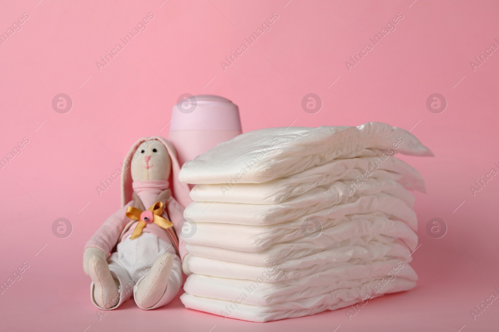 Photo of Diapers and baby accessories on pink background
