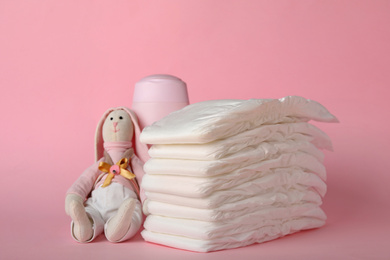 Photo of Diapers and baby accessories on pink background