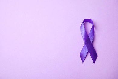 Photo of Purple ribbon on lilac background, top view with space for text. Domestic violence awareness