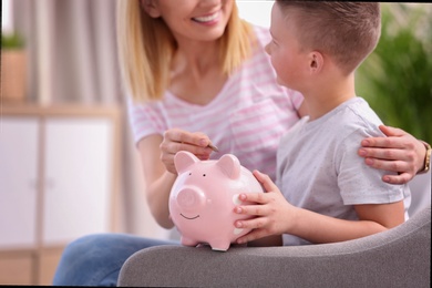 Family with piggy bank and money at home