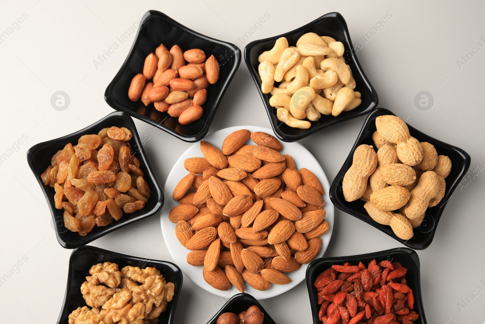 Photo of Bowls with dried fruits and nuts on beige background, flat lay