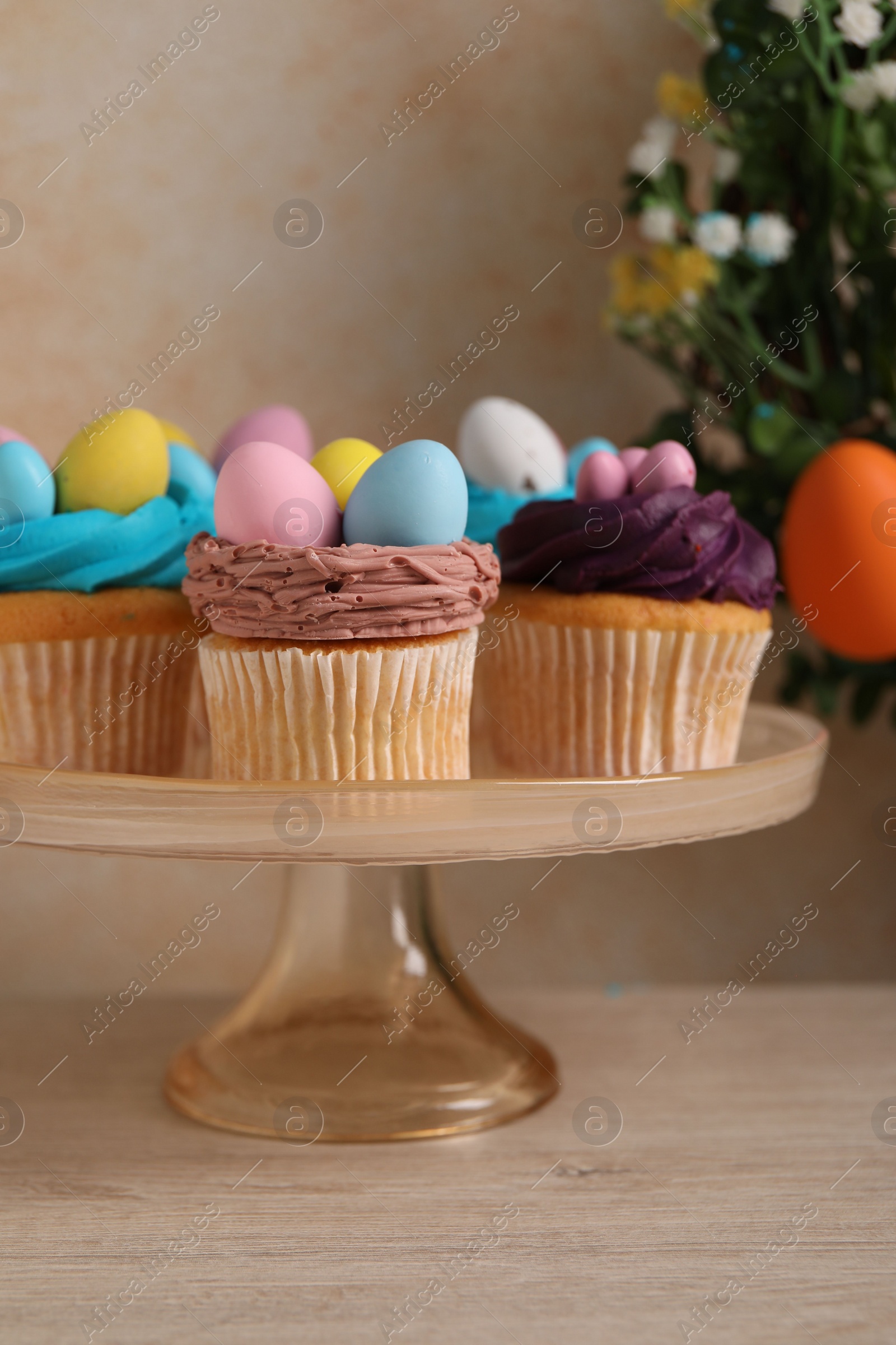 Photo of Tasty cupcakes with Easter decor on wooden table