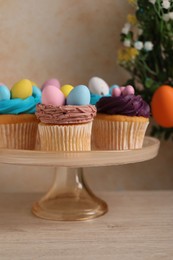 Photo of Tasty cupcakes with Easter decor on wooden table