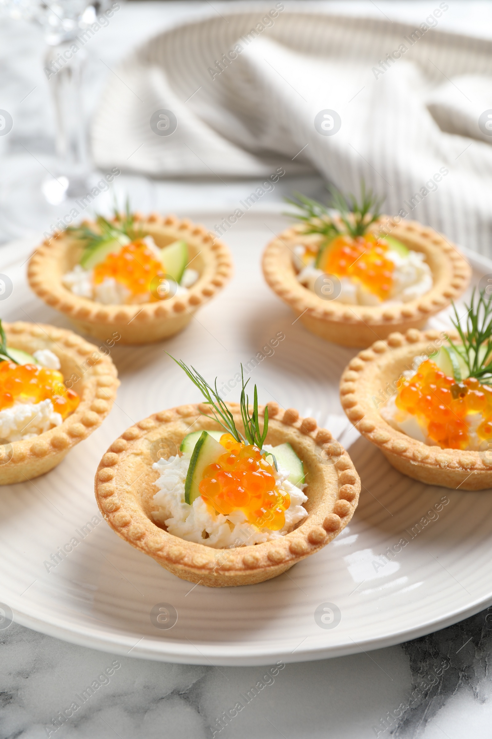 Photo of Delicious canapes with red caviar on white marble table