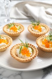 Photo of Delicious canapes with red caviar on white marble table