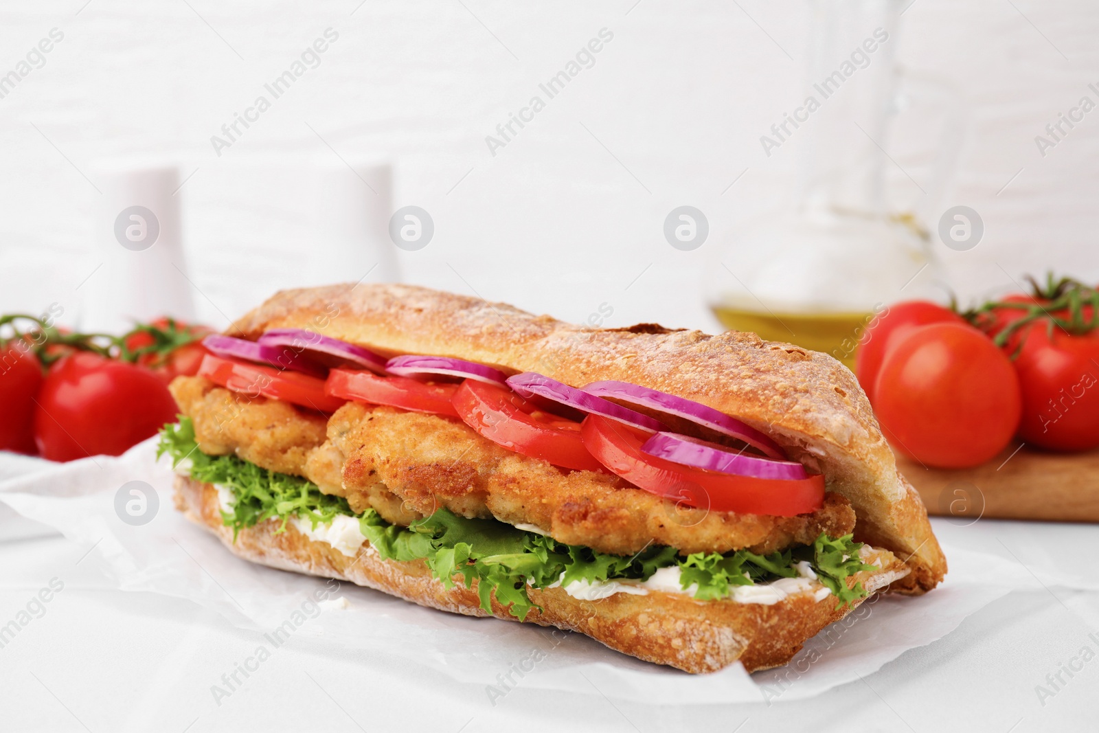 Photo of Delicious sandwich with schnitzel on white tiled table