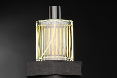 Photo of Luxury men`s perfume in bottle against dark background