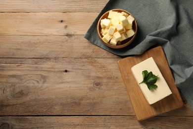 Photo of Tasty butter with parsley on wooden table, flat lay. Space for text