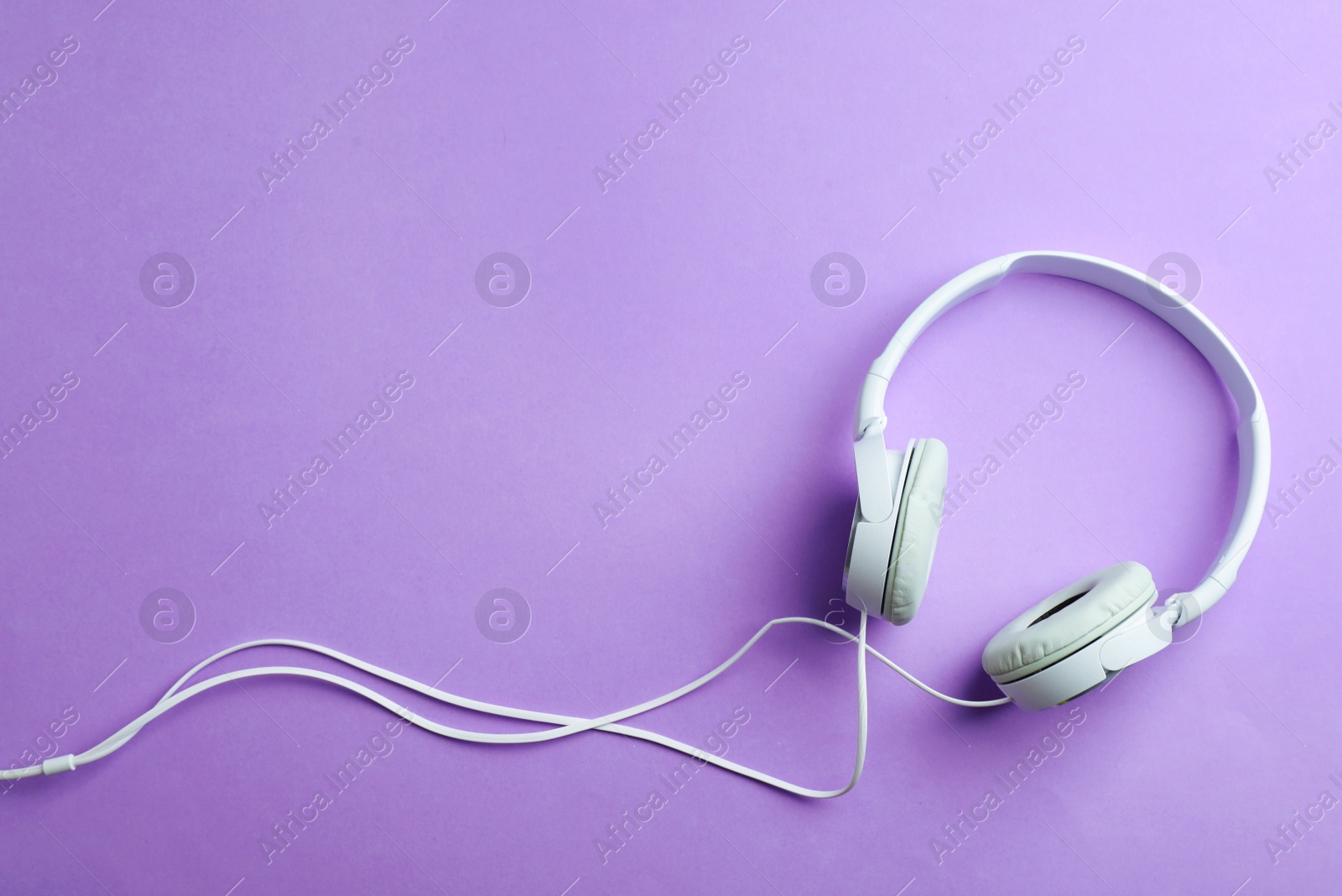 Photo of Stylish headphones on color background, top view. Space for text