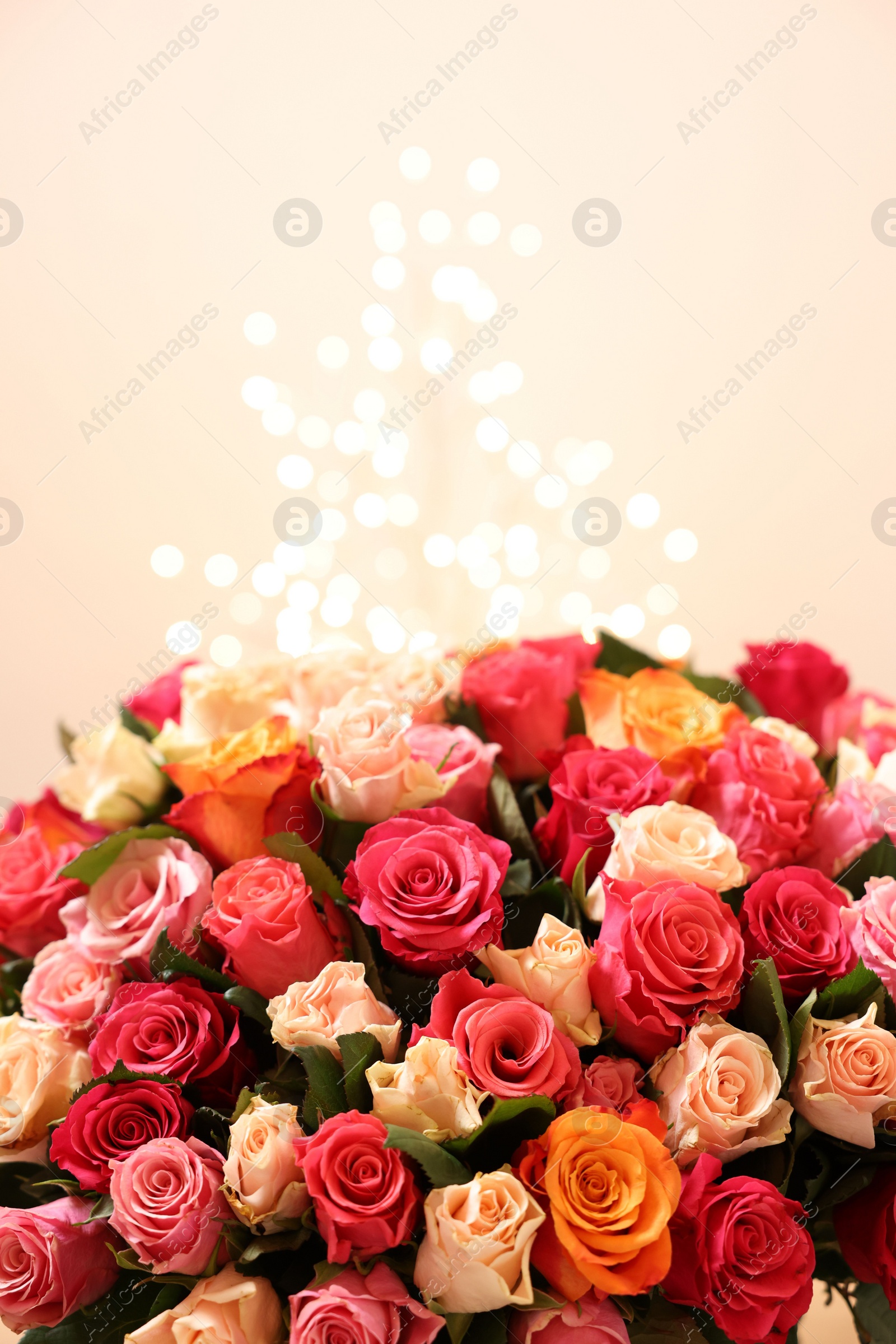 Photo of Beautiful bouquet of colorful roses on beige background