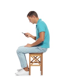 Photo of Man with poor posture using smartphone while sitting on stool against white background